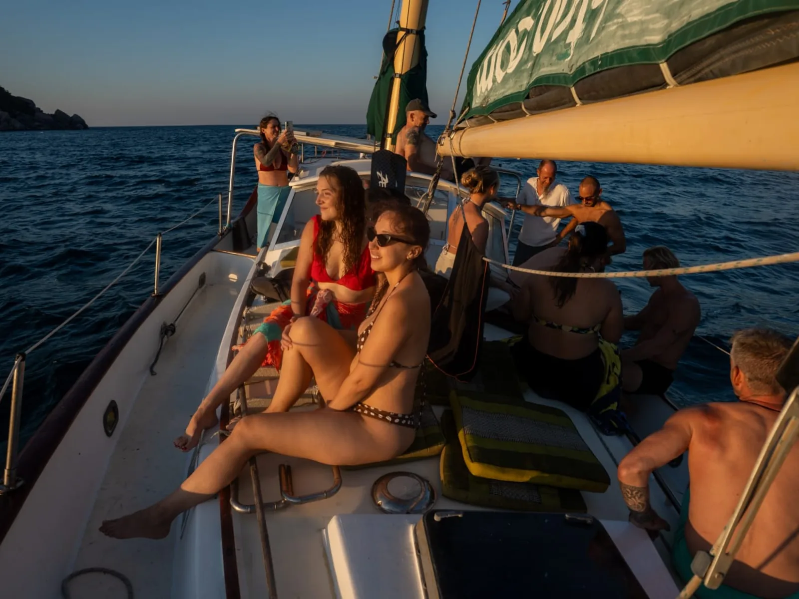 Guests relaxing on deck at golden hour during a sunset sail